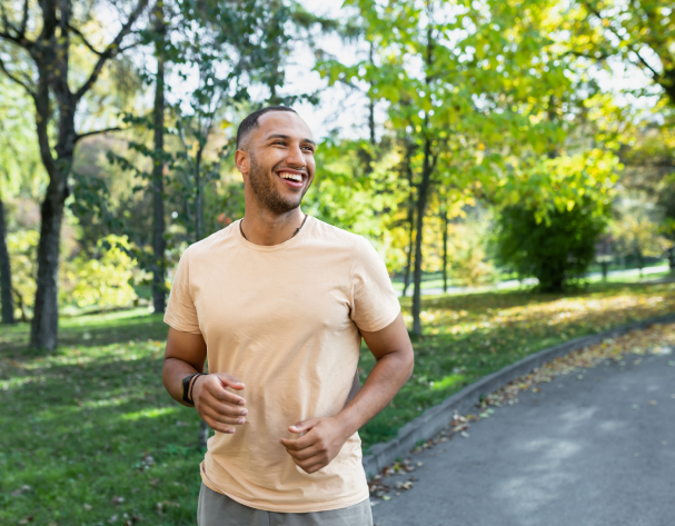 A Young Man in a Park Smiling after Pulse PEMF Therapy at Divine MedSpa